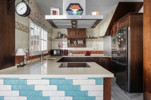 a kitchen with a tile island with a clock at Estribor 25 in Novo Sancti Petri