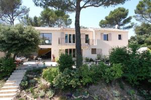 a large white house with trees in front of it at superb villa with private pool, with magnificent view of the luberon, in the heart of provence, 8 persons in Puget