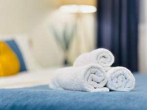 アルマトイにある417I3 Sky Blue Apartments Sholpan cityのベッドの上に置かれたタオルの山