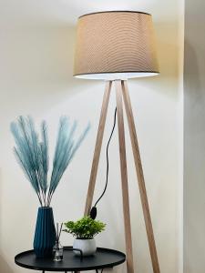 a lamp on a table with a plant on it at Sky Blue Apartments 417/3 in Almaty