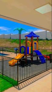 a playground with colorful slides and umbrellas at Apartamento Cuiabá in Cuiabá