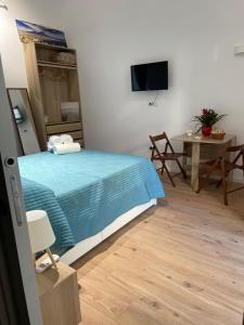 Un dormitorio con una cama, una mesa y un televisor. en NaBi Suite Riviera, en Nápoles