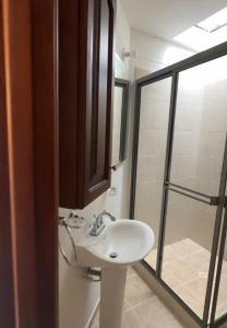 a bathroom with a sink and a glass shower at HACIENDA EL ENSUEÑO in Floridablanca