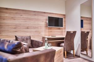 a living room with a couch and a table with chairs at Landhotel Gruber in Waldmünchen