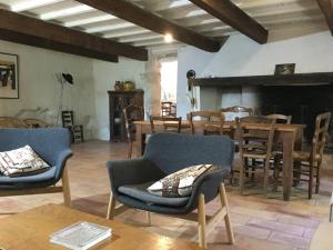 ein Wohnzimmer mit Stühlen, einem Tisch und einem Kamin in der Unterkunft typical provencal farm in an exceptional natural site, the alpilles park - 8 people. in Les Fléchons