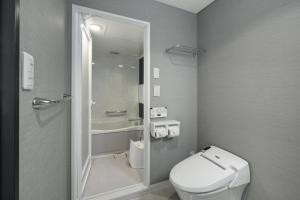 a small bathroom with a toilet and a shower at Grand Park Hotel Panex Tokyo in Tokyo