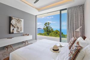 a bedroom with a large window with an elephant picture at Sukkho Samui Estates in Chaweng Noi Beach +168 photos