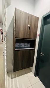a wooden cabinet in a bathroom with a door at Duan Homestay at Cybersouth in Kampung Dengkil