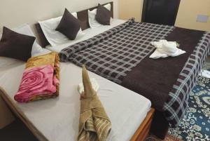 two beds in a hotel room with towels on them at GRG Mountview By Darjeeling in Darjeeling
