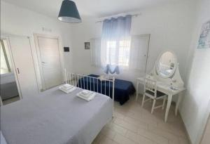 - une chambre avec un lit, un bureau et un miroir dans l'établissement Borgata Mazzarelli 2, à Marina di Ragusa