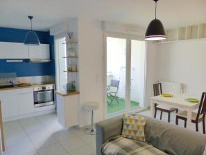 a living room and kitchen with a couch and a table at Le Zambeze - Calme et spacieux - parking couvert in Saint-Herblain