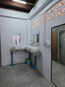 a bathroom with two sinks and two mirrors at Say My Name in Koh Phangan