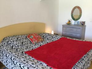 a bedroom with a bed with a red blanket at beautiful vacation home with pool located in robion with a pretty view on the luberon. 8 people. in Robion en Luberon