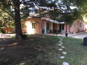 a house with a tree in the yard at beautiful vacation home with pool located in robion with a pretty view on the luberon. 8 people. in Robion en Luberon