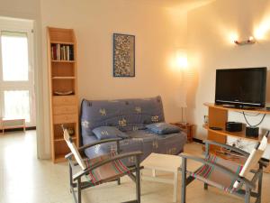 ein Wohnzimmer mit einem Sofa und einem TV in der Unterkunft Appartement Argelès-sur-Mer, 2 pièces, 5 personnes - FR-1-225-426 in Argelès-sur-Mer
