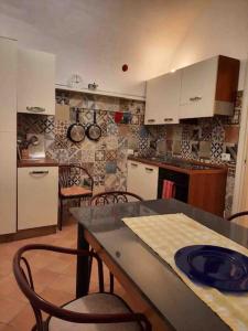 a kitchen with white cabinets and a table and chairs at Panoramic house Atrani 5 Amalfi Antica appartamenti in Atrani