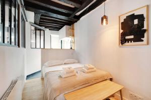 a small room with a bed and a wooden table at Cosy Hut in the Middle of Bastille in Paris