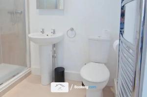 uma casa de banho branca com um WC e um lavatório em Charming 1 Bedroom Flat By J F SUITES Short Lets & Serviced Accommodation with WiFi em Kent
