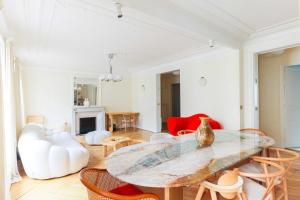 uma sala de estar com uma mesa de vidro e cadeiras em Beautiful 95m2 flat in the heart of Neuilly Sur Seine em Neuilly-sur-Seine