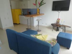 sala de estar con 2 sillas azules y TV en Conjunto Campestre 10min Centro Eventos Valle del Pacifico, Aeropuerto en Yumbo