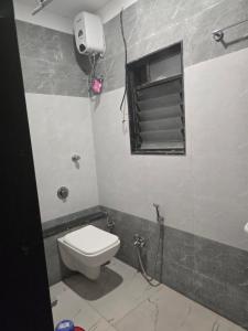 ein Bad mit einem WC und einem Fenster in der Unterkunft HOTEL RAMJI in Karmād