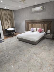 ein Schlafzimmer mit einem großen Bett und einem Tisch in der Unterkunft HOTEL RAMJI in Karmād