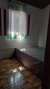 Cama en habitación con ventana en Casa Nobre, en Pirenópolis