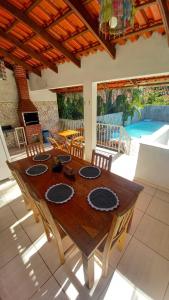 uma mesa de madeira numa sala de estar com piscina em Casa Nobre em Pirenópolis