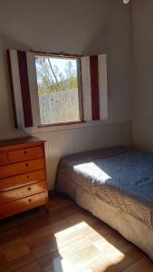 um quarto com uma cama, uma janela e uma cómoda em Casa Nobre em Pirenópolis