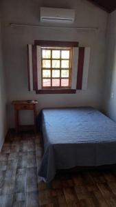 a bedroom with a bed and a window at Casa Nobre in Pirenópolis