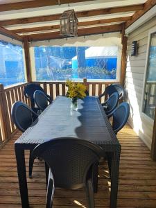 a table and chairs on a deck with a table and a light at Mobil home les dunes de contis "domino" in Saint-Julien-en-Born