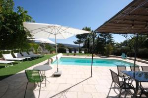 very beautiful villa with private pool in the luberon enjoying a magnificent view of the durance valley, located in puget – 10 people. في Puget: مسبح وكراسي وطاولة ومظلة