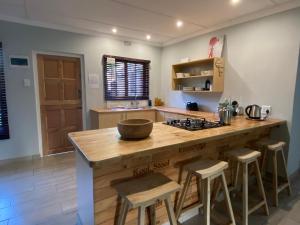 a kitchen with a large wooden island with bar stools at Cape Chameleon in Nottingham Road