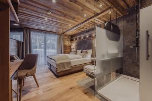 a bedroom with a bed and a desk in a room at Hotel Vermala in Sankt Gallenkirch