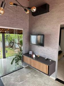 - un salon avec une télévision murale dans l'établissement Studio no centro de Rio Verde., à Rio Verde