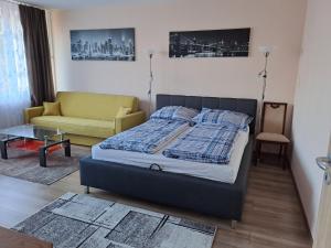 1 dormitorio con 1 cama y 1 sofá en Kaptár lakás, en Komárom