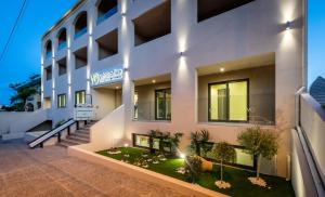 a large white building with plants in front of it at White Olive Elite Rethymno in Sfakaki