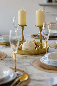 a table with candles and plates and glasses on it at Royal Garden Apartment in Wilanow by Renters Prestige in Warsaw