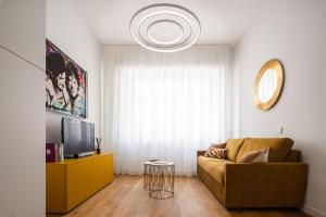 een woonkamer met een bank en een televisie bij San Babila Design Apartment R&R in Milaan