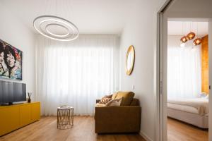 een woonkamer met een bank en een bed bij San Babila Design Apartment R&R in Milaan