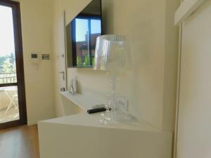 a white bathroom with a glass vase on a counter at Casa Jotti in Cardano al Campo