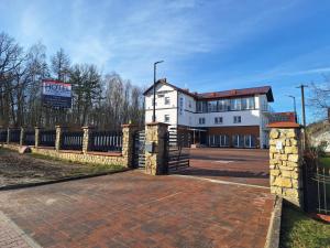 a building with a fence in front of it at Comfort Stay, EV, Parking in Bolesławiec
