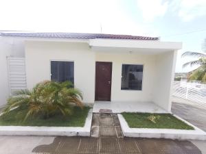 ein weißes Haus mit einer Tür und einer Palme in der Unterkunft Paraíso Praia Bela in Pitimbu