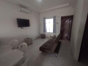 a living room with a couch and a television at Paraíso Praia Bela in Pitimbu