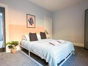 a bedroom with a large bed with white sheets at Stylish 3-bedroom home in Canterbury City-Centre - Superb Location! in Canterbury