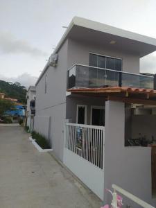 a white house with a porch and a balcony at Casa do Píer in Governador Celso Ramos