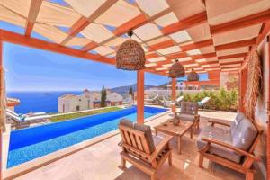 a house with a pool and a patio with chairs at Villa Blue, LaVanta, Kalkan in Kalkan
