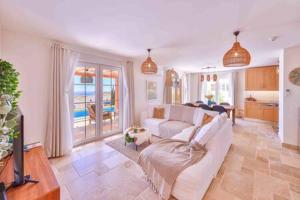 a living room with a white couch and a kitchen at Villa Blue, LaVanta, Kalkan in Kalkan