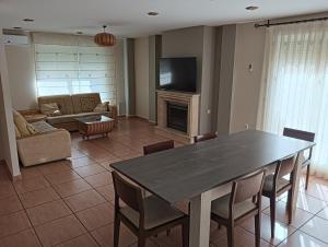 ein Wohnzimmer mit einem Tisch, Stühlen und einem Sofa in der Unterkunft CASA CLIMATIZADA VACACIONAL in Villalonga