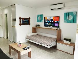 ベナルマデナにあるApartamento Aguilaのベッド1台、薄型テレビが備わる客室です。
